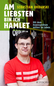 Cover vom Buch "Am liebsten bin ich Hamlet" von Sebastian Urbanski. Zu sehen ist ein Foto von ihm, wie er in einem roten T-Shirt mit zwei weißen Streifen , die Arme verschränkt, mit einer runden Brille schauend in die Kamera blickt. Er wirkt zufrieden und souverän. Im Hintergrund sind Plakate von Theaterstücken zu sehen.