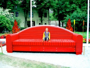 Nina LaGrande sitzt auf einem überdimensionalen, roten Holzsofa in einem Park. (Bild: Privat)