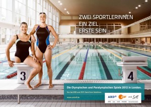 Plakat zu der Kampagne von ARD und ZDF zu den olympischen und paralympischen Spielen. Christiane Reppe und Franziska Schreiber am Beckenrand der Schwimmhalle.