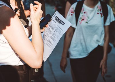 Eine Frau hält eine Liste in der Hand anhand dessen sie die Orte in der Wheelmap makiert.