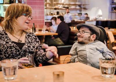 Melissa Graham und Raul Krauthausen unterhalten sich. Beide sitzen im Rollstuhl.