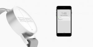 Eine Smartwatch mit erhobener 3-D Brailleschrift ist zu sehen. Daneben eine Smartphone.