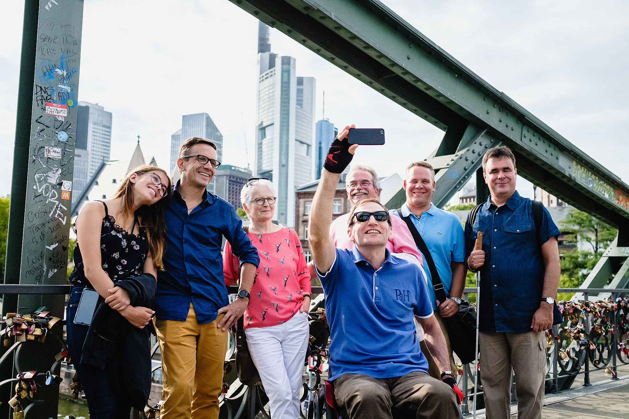 eine gruppe von menschen macht ein selfie vor einer hochhaus kulisse